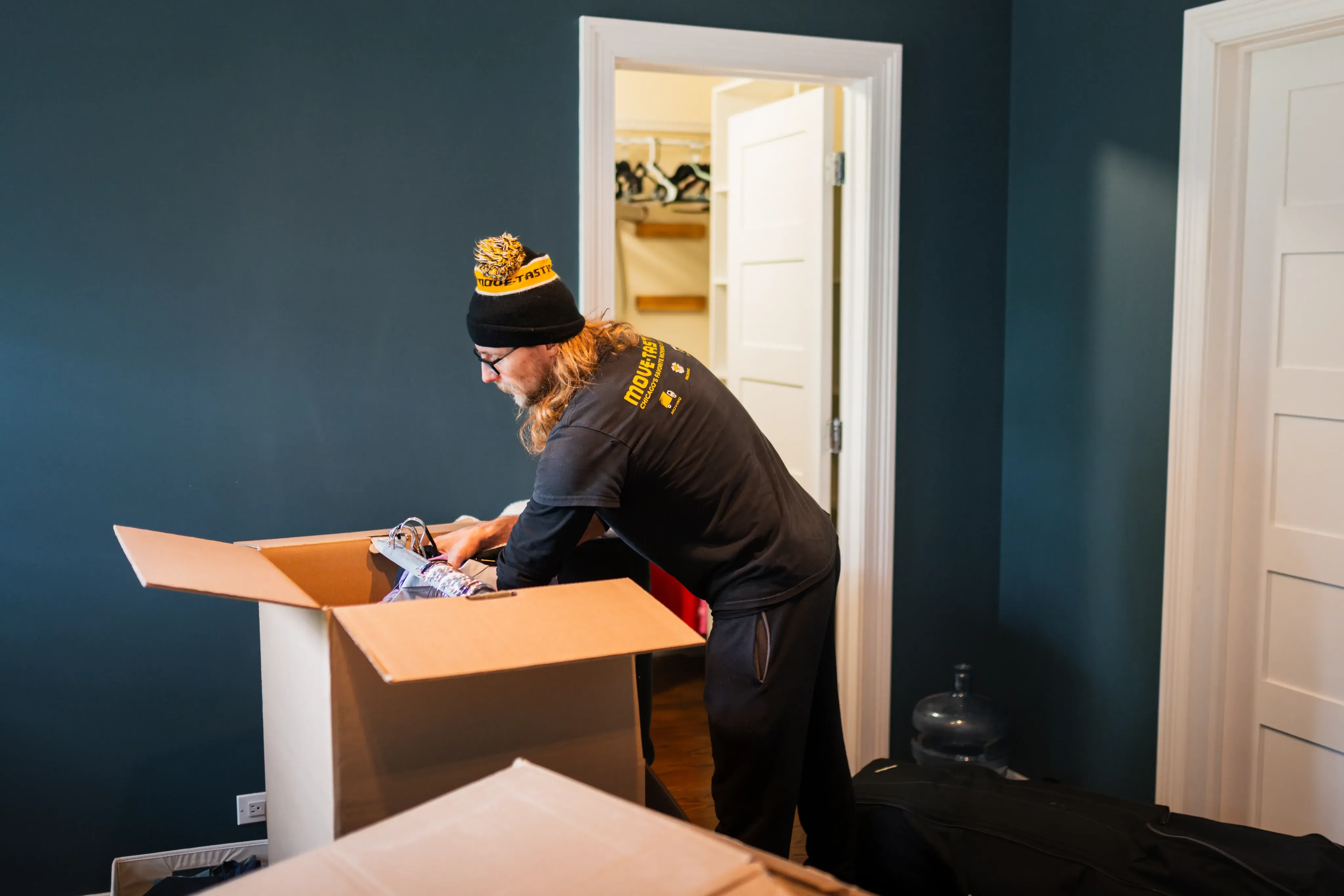 Move-tastic! mover packing a box in a bedroom