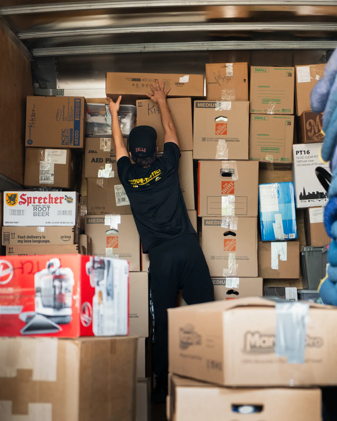 Mover loading and arranging boxes inside a moving truck